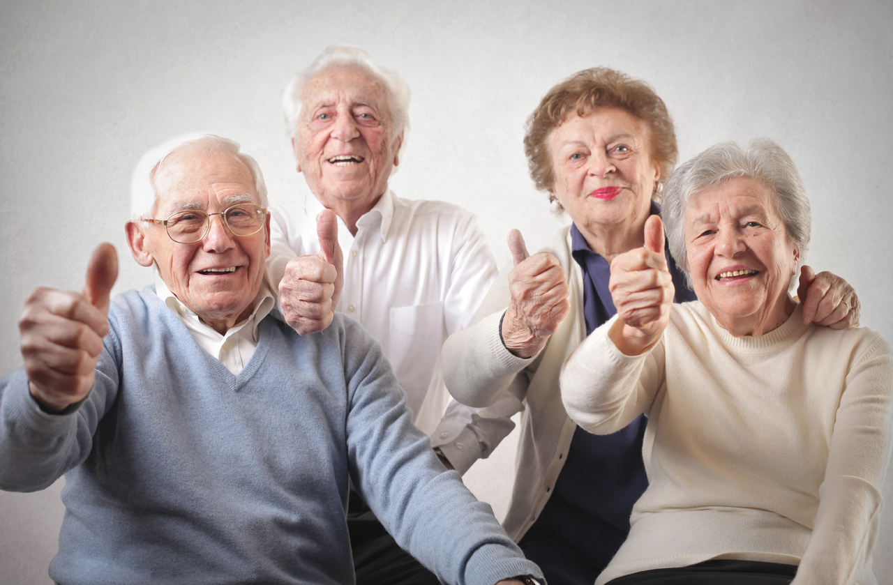 Vier Senioren halten Daumen hoch